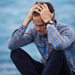 Man sitting with hands on head